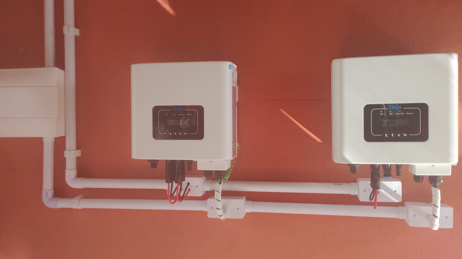 Dois inversores solares instalados lado a lado, com fiação organizada